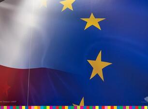 Przenikające się dwie flagi- Polski i Unii Europejskiej.