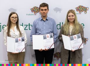 Troje laureatów konkursu prezentuje dyplomy.