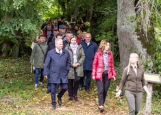 Grupa osób idzie ścieżką leśną