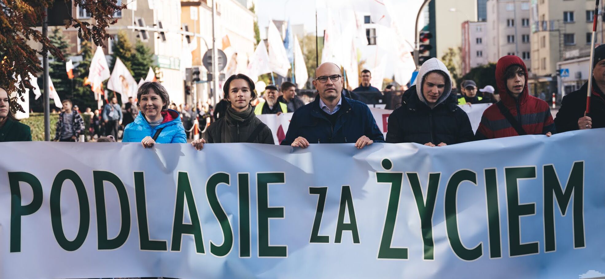 Marszałek Artur Kosicki i uczestnicy wydarzenia niosą baner z napisem "Podlasie za życiem"