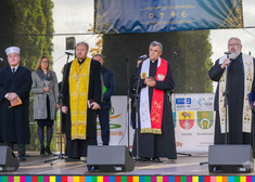 Duchowni różnych wyznań stoją na scenie. Za nimi uczestnicy wydarzenia