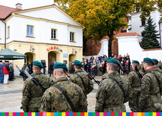 Żołnierze stojący tyłem przed tablicą pamiątkową 