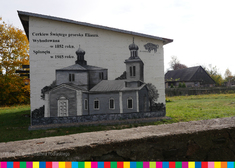 Mural z kapliczką na ścianie budynku.