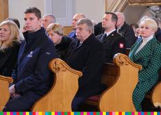 Uczestnicy uroczystości siedzą w ławkach w kościele