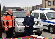 Wicemarszałek Olbryś i ratownik medyczny na tle ambulansów z napisem Nadzieja