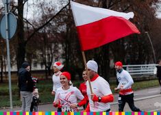 biegnący ludzie z flagą biało-czerwoną