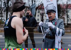 mężczyzna w stroju Marszałka Piłsudzkiego zakładający medal