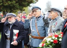 Mężczyźni ze Związku Piłsudczyków składają znicz i wieniec pod pomnikiem