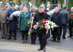 Członek zarządu Marek Malinowski niesie biało-czerwony wieniec