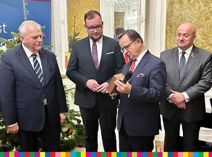 Marszałek Ortyl przekazuje statuetkę wicemarszałkowi  i przewodniczącemu sejmiku