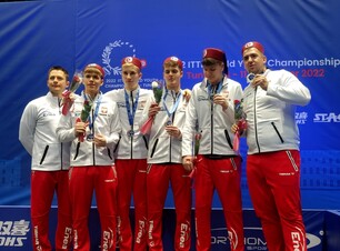 sześciu mężczyzn z medalami, ubrani są w biało-czerwone stroje sportowe