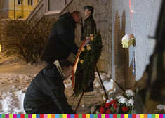 Dwóch mężczyzn składa kwiaty przy Pomniku Katastrofy Smoleńskiej