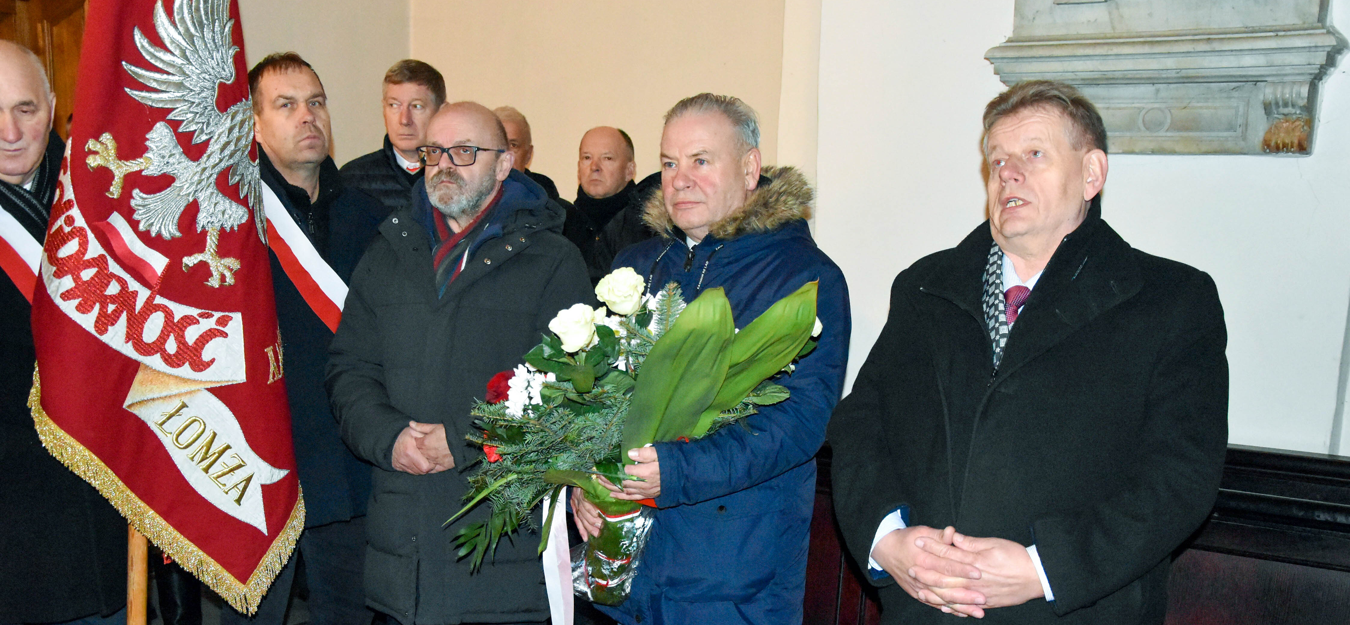 Marszałek Olbryś trzyma kwiaty, obok stoją uczestnicy wydarzenia