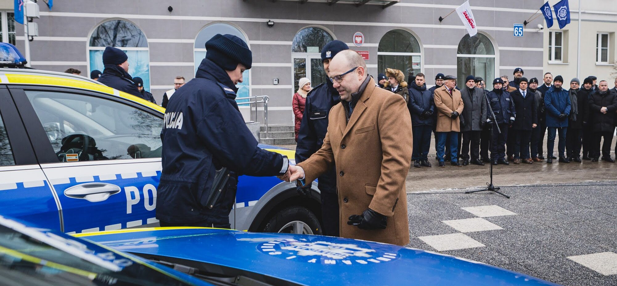 Marszałek Artur Kosicki podaje dłoń policjantowi