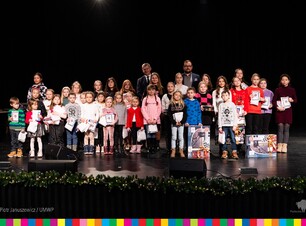 Na scenie gromada dzieci wraz z burmistrzem Łap i Wicemarszałkiem Województwa Podlaskiego