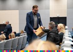 Wicemarszałek Sebastian Łukaszewicz dzieli się z ludźmi prezentami z torby