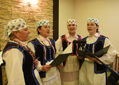 Cztery kobiety ubrane w stroje ludowe śpiewają