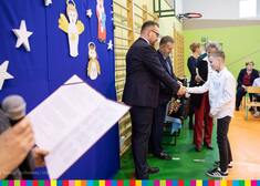 Wicemarszałek Sebastian Łukaszewicz podaje chłopcu rękę