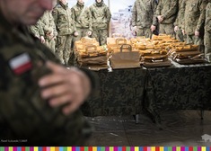 Żołnierze stoją wokjół stołu z upominkami