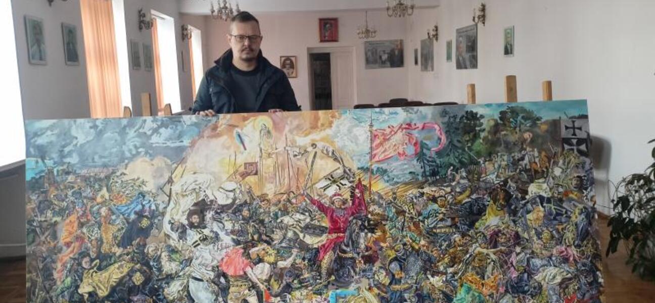 Tomasz Balicki prezentuje obraz.