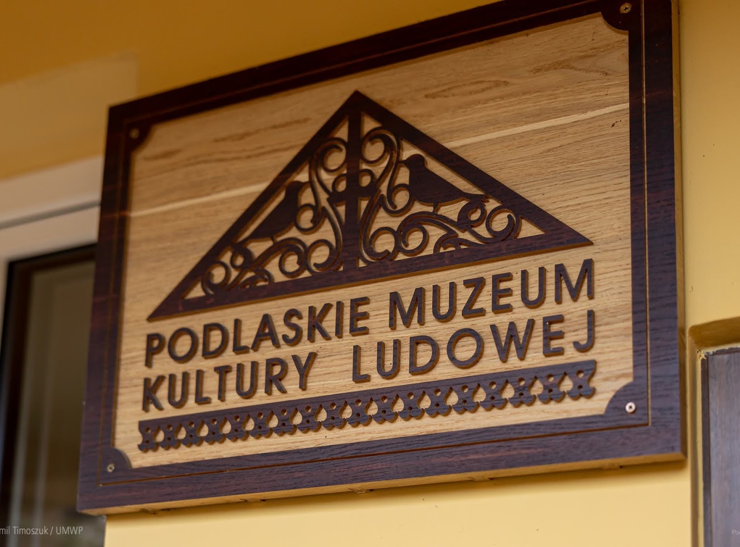 Drewniany logotyp Podlaskiego Muzeum Kultury Ludowej