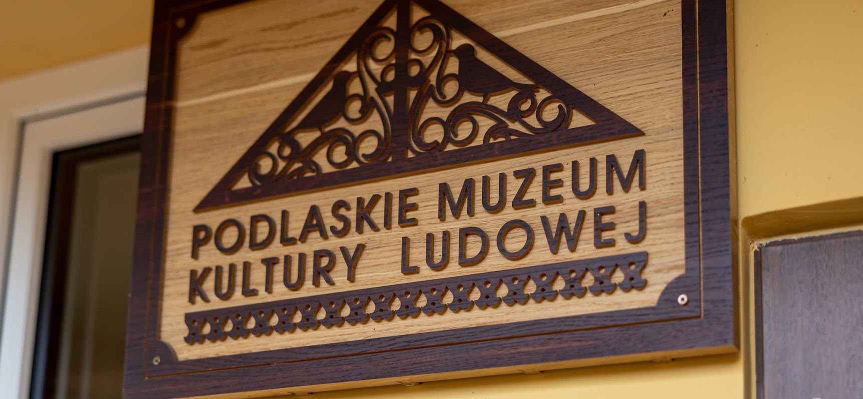 Drewniany logotyp Podlaskiego Muzeum Kultury Ludowej
