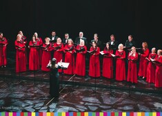 Grupa osób na scenie podczas śpiewania kolędy
