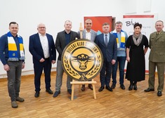 Członek zarządu Marek Malinowski i siedem osób przy logo bielskiego klubu sportowego
