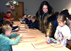 Katarzyna Ancipiuk, dyrektor PMKL pokazuje dzieciom jak wykonywać czynności