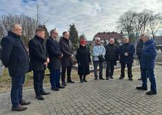 grupa osób, w tym członek zarządu Marek Malinowski stoją na cmentarzu