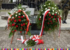 biało-czerwone wieńce kwiatów złożone pod pomnikiem ku czci Sybiraków
