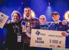 zespół Bad Falcon trzyma czek i pozuje do wspólnego zdjęcia