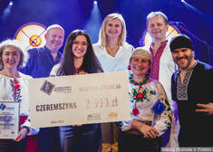 członkowie zespołu Czeremszyna pozują do wspólnego zdjęcia, część z nich trzyma czek na kwotę 2,5 tys. zł