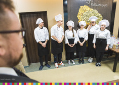 młodzi kucharze stoją w rzędzie przed komisją konkursową