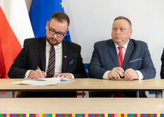Wicemarszałek Łukaszewicz podpisuje umowę. Obok siedzi wójt gminy Wysokie Mazowieckie