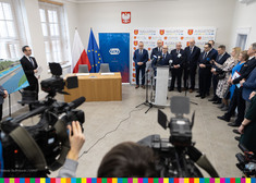 mężczyźni stojący przy ściance z logo Augustowa podczas konferencji prasowej