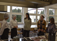 Iwona Krzyżanowska rozmawia z kobietami ubranymi w kulinarne stroje
