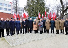 Grupa mundurowych oraz cywilów stoi na chodniku przed pomnikiem Danuty Siedzikówny 