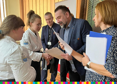 Dyrektor szkoły Przemysław Chraniuk wręcza dyplomy uczniom w towarzystwie nauczycieli