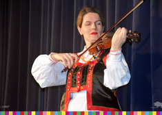 kobieta w stroju ludowym gra na skrzypcach