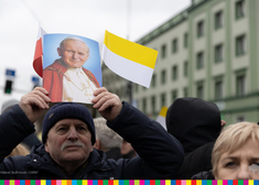 Mężczyzna trzyma nad głową zdjęcie papieża