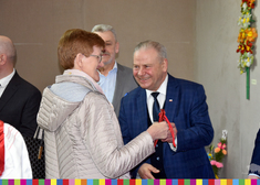 Uśmiechnięty wicemarszałek Marek Olbryś przekazuje upominek kobiecie