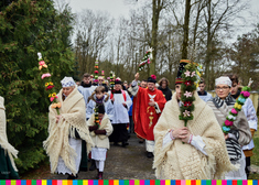 Wierni, kapłani oraz będące na pierwszym planie kobiety ubrane w ludowe stroje maszerują z palmami