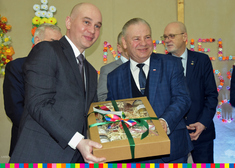 Wicemarszałek Marek Olbryś z drugą osobą trzymają w dłoni pudełko pełne słoików zawiązane w kokardkę 