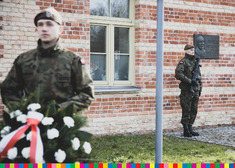 Żołnierze przed pamiątkową tablicą.