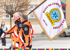 pracownicy Wojewódzkiej Stacji Pogotowia Ratunkowego w Łomży niosą sztandar 
