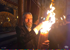 Mężczyzna trzyma dłoń w płomieniach Świętego Ognia