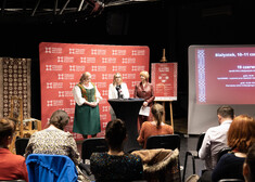 trzy kobiety stojące przy stole podczas konferencji prasowej