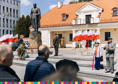 Pomnik Józefa Piłsudskiego. Przy nim stoją żołnierze na warcie. Obok powiewają sztandary biało-czerwone