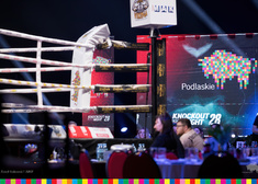 Widok na ring bokserski i plakat z logiem Województwa Podlaskiego